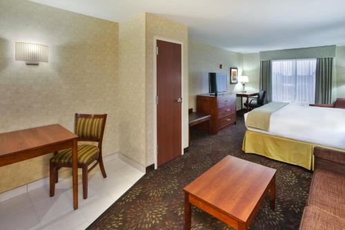 a hotel room with a bed and a desk and a table at Holiday Inn Express Frankenmuth by IHG in Frankenmuth