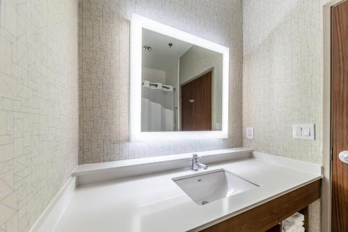 Baño blanco con lavabo y espejo en Holiday Inn Express & Suites Fort Worth - Fossil Creek, an IHG Hotel, en Fort Worth