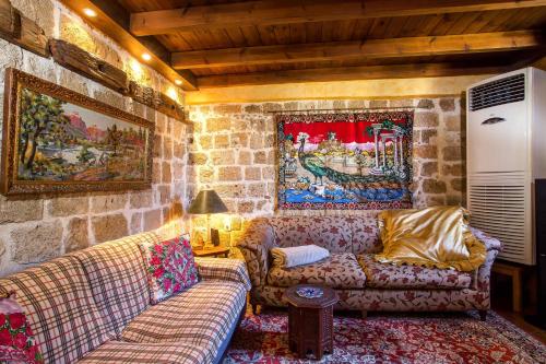 a living room with two couches and a stone wall at CASA DI ALEJANDRO in Rhodes Town