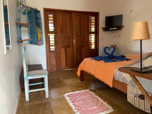 杰里科科拉Pousada Janela da Cor的卧室配有床、椅子和门
