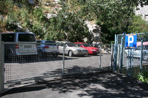 a gate with cars parked in a parking lot at Hotel Villa Dvor in Omiš