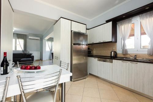 a kitchen with a table with a plate of apples on it at Lilium Villa, summer aroma, By ThinkVilla in Perama