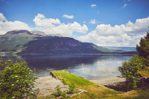 ein großer Wasserkörper mit Bergen im Hintergrund in der Unterkunft Sommerhotellet in Vang I Valdres