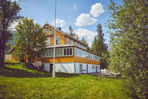 uma casa grande no topo de uma colina com árvores em Sommerhotellet em Vang I Valdres