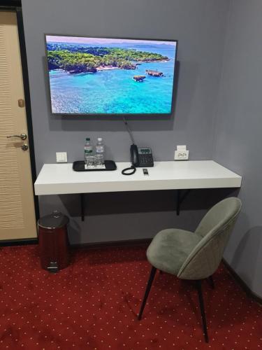 a white desk with a computer monitor and a chair at LEX Trend Hotel in Irpin'