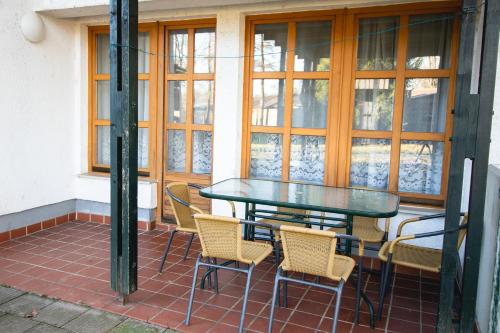 a table and chairs on a patio with windows at POČITNIŠKI APARTMAJI - Extraordinary apartment in Banovci in Veržej