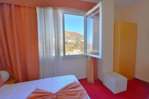 a bedroom with a bed and a large window at Jolly Hotel in Lezhë