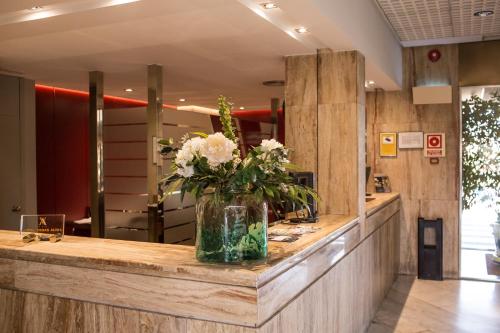 a vase of flowers on a counter in a salon at Hotel Vegas Altas in Don Benito