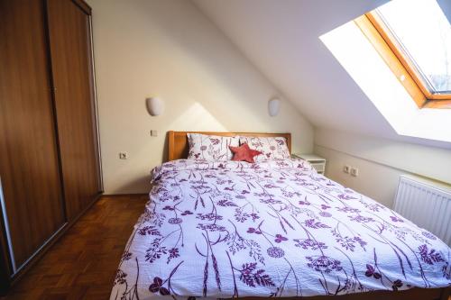 1 dormitorio con 1 cama con edredón morado en Relax apartment in Terme Banovci spa resort, en Veržej