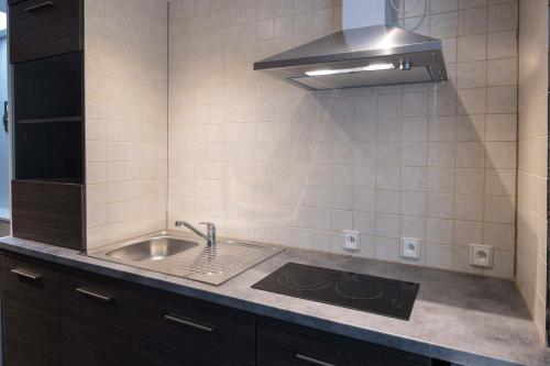 a kitchen with a sink and a stove at Logies De blauwe regen in Beveren