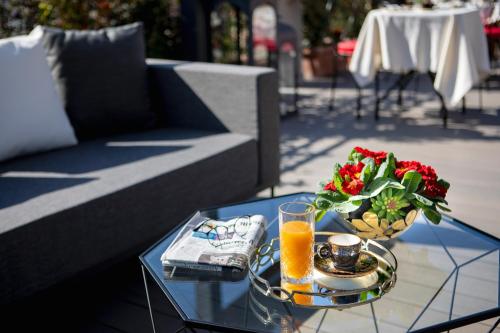 a coffee table with a glass of orange juice and a bowl of flowers at Dharma Boutique Hotel & SPA in Rome