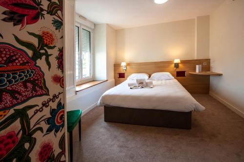 Habitación de hotel con cama y ventana en Hostellerie Bon Pasteur en Angers