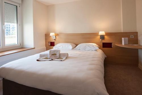 a hotel room with a large bed with two books on it at Hostellerie Bon Pasteur in Angers