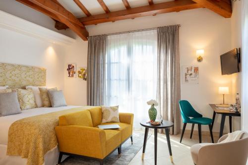a bedroom with a bed and a chair and a window at Domaine de l'Astragale in Saint-Tropez