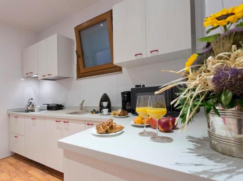 a kitchen with a plate of food and glasses of orange juice at Palazzo Piccolomini in Siena