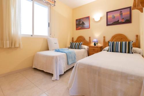 um quarto com 2 camas e uma janela em Homes & Go Mare Internum I em La Pineda