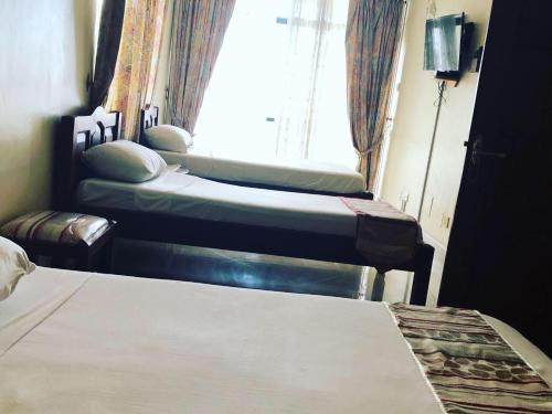 a room with two beds and a window at Tudor Water Sports Hotel in Mombasa