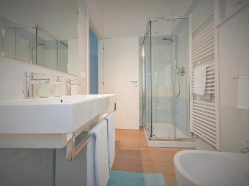 a white bathroom with a sink and a shower at Villa Due Giardini in Padova