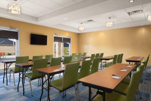 a conference room with wooden tables and green chairs at Holiday Inn Express & Suites Edinburg- Mcallen Area by IHG in Edinburg