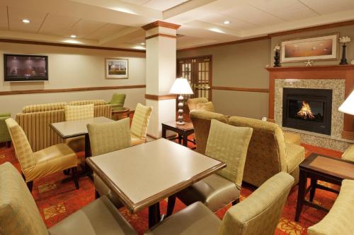 a waiting room with tables and chairs and a fireplace at Holiday Inn Express Hotel & Suites Freeport by IHG in Freeport
