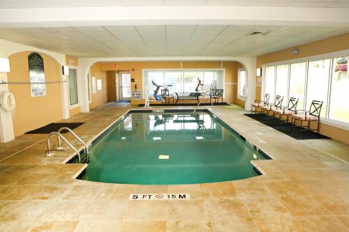 uma piscina num quarto grande com cadeiras em Holiday Inn Express Hotel & Suites - Sumter, an IHG Hotel em Sumter
