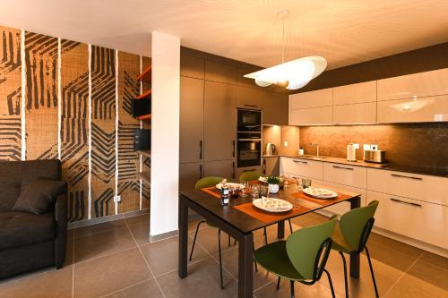 une cuisine et une salle à manger avec une table et des chaises dans l'établissement L'Estrade La Costière - 2 chambres avec vue sur le Lac, à Annecy