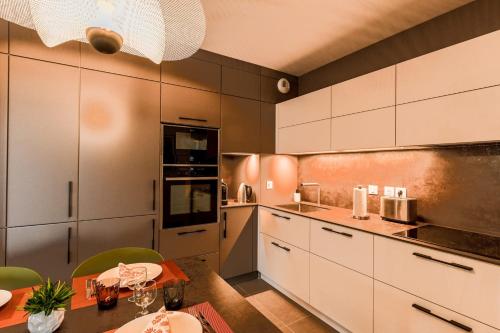 - une cuisine avec des placards blancs et une table à manger dans l'établissement L'Estrade La Costière - 2 chambres avec vue sur le Lac, à Annecy