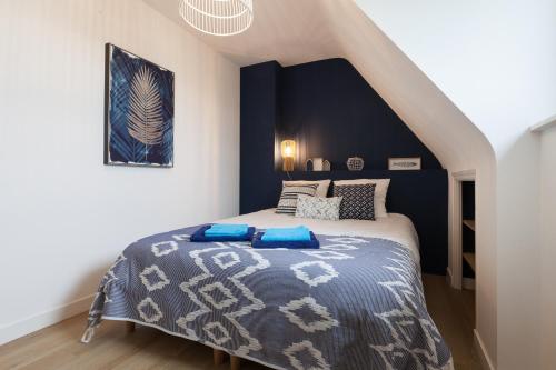 a bedroom with a bed with a blue accent wall at Villa ty Oyats, face à l'océan nouveautés 2024 in Plouescat