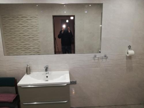 a man taking a picture of a bathroom mirror at Apartament u Wioli in Okleśna
