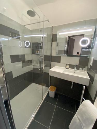 a bathroom with a shower and a sink at Hotel Courbet in Juan-les-Pins