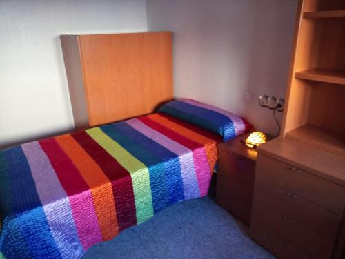 łóżko z kolorowym kocem w sypialni w obiekcie La Conchita w mieście Almería