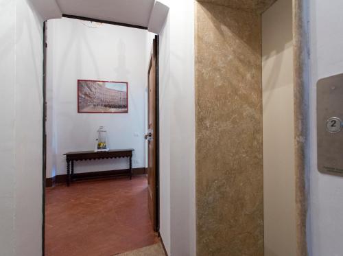 a hallway with a door leading to a room with a table at Palazzo Piccolomini in Siena