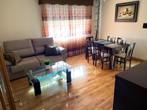 a living room with a couch and a table at Apto Alma Parking y Piscina GRATIS in Zaragoza