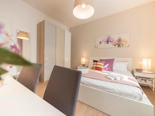 - une chambre avec un lit et une table avec des chaises dans l'établissement Villa Due Giardini, à Padoue