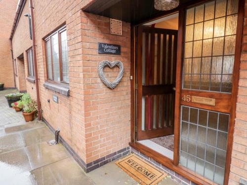 a heart sign on the side of a brick building at Valentines Cottage in Stratford-upon-Avon