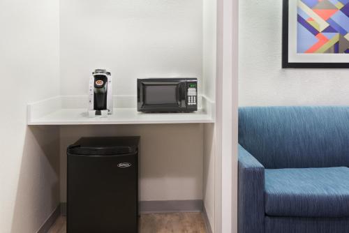 a microwave and a chair in a room at Holiday Inn Express & Suites - Nearest Universal Orlando by IHG in Orlando