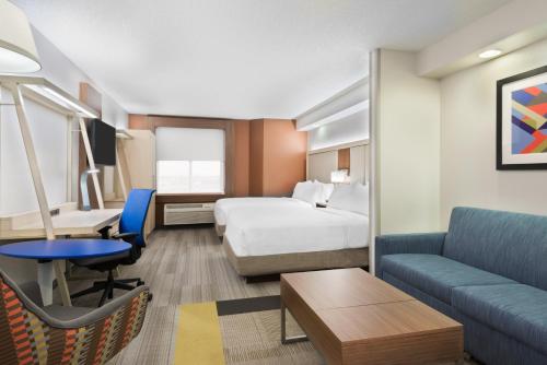 a hotel room with a bed and a couch at Holiday Inn Express & Suites - Nearest Universal Orlando by IHG in Orlando
