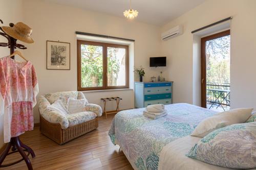 梅塔的住宿－Villa la Quercia，一间卧室配有一张床和一把椅子