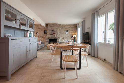 une cuisine avec une table et des chaises dans une pièce dans l'établissement Villa ty Oyats, face à l'océan nouveautés 2024, à Plouescat