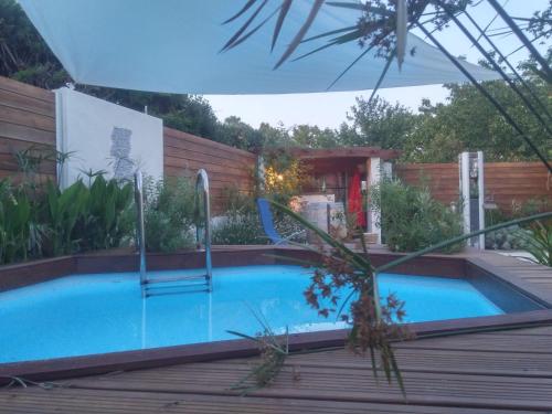- une piscine dans un jardin avec une terrasse en bois dans l'établissement Secret Garden - Chez Gilles et Tra - Maison d hôte -T2 super mignon, neuf et indépendant , dans cadre agréable et zen, à Valergues