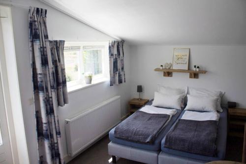 um quarto com 2 camas individuais e uma janela em Bed & Breakfast de Lindevallei em Oldeberkoop
