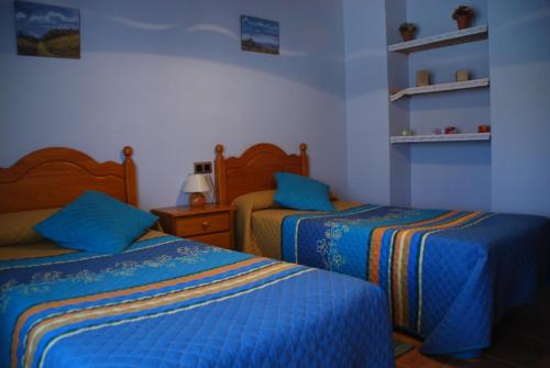 1 dormitorio con 2 camas con sábanas azules y amarillas en Casa La Catalina, en Beceite