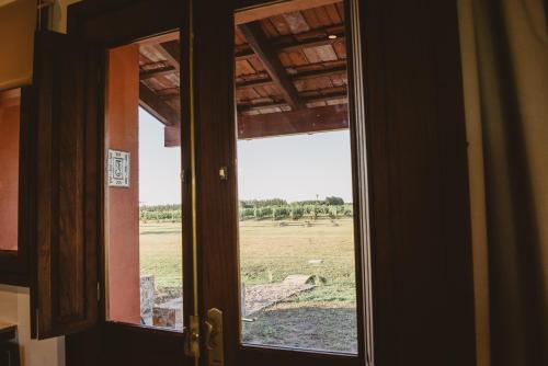 an open door with a view of a field outside at El Legado Wine Lodge in Carmelo