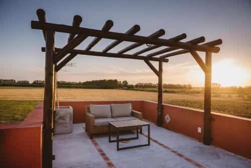 a pergola with a couch and a table on a patio at El Legado Wine Lodge in Carmelo