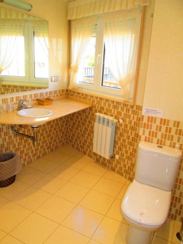 łazienka z toaletą i umywalką w obiekcie Complexo Alameda w mieście Viveiro