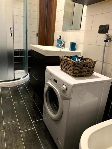 a bathroom with a washing machine with a basket on it at Appartamento “La Corte” in Paderno Dugnano