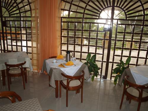 un restaurante con mesas y sillas y una gran ventana en Vila Marija-Roza en Drage