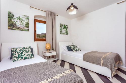 a bedroom with two beds and a window at VILLA REMUSIC Pool, whirlpool, Sauna,4 bedrooms, amazing landscape in Smolonje