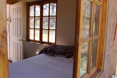 Schlafzimmer mit einem Bett und einem Fenster in der Unterkunft Cabaña Nachitor in San Pedro de Atacama