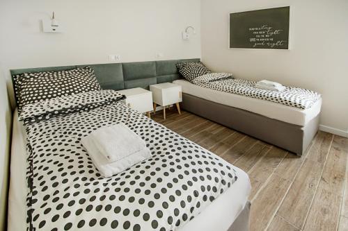 1 dormitorio con 2 camas con lunares en blanco y negro en Apartament Centrum XL - Komfortowe Noclegi, en Piaseczno